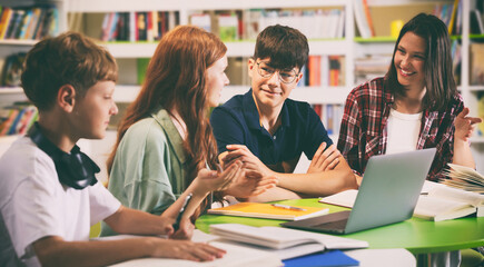 Students in campus library. Teenage girls and boys studying at desk together © New Africa