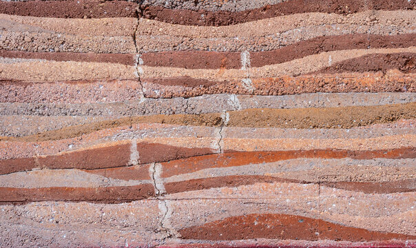 Full frame shot of an earthen wall texture of clay house structure. These walls are constructed by ramming a mixture of aggregates, including gravel, sand, silt and a small amount of clay.