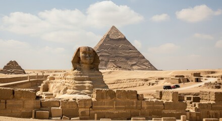 Panoramic view of the Great Sphinx of Giza and the Pyramids of Khafre and Menkaure, standing majestically in the sunny desert landscape of the Giza Necropolis, Egypt.