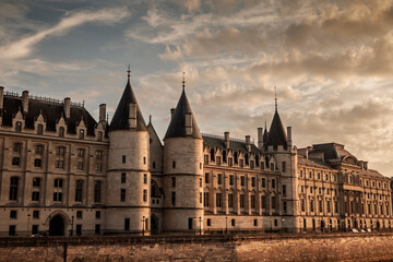 La Conciergerie on the Quai de l'Horloge at sunset, with turrets and stone facade along the Seine in Paris, France. The historic courthouse, former prison is a major attraction on Ile de la Cite. © Jerome