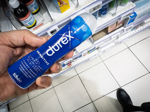 HYERES, FRANCE - SEPTEMBER 27, 2025: A shopper holds a bottle of Durex Sensitive personal lubricant in a supermarket in Hyeres, France. Durex is a british brand of sexual products and condoms.