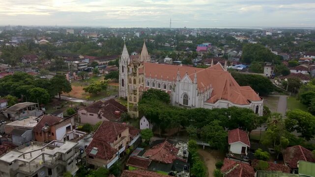 Drone footage of St. Sebastian's Church in Negombo, Sri Lanka.
The historic Catholic church, with its white fa&ccedil;ade and twin towers, is surrounded by a tropical cityscape.