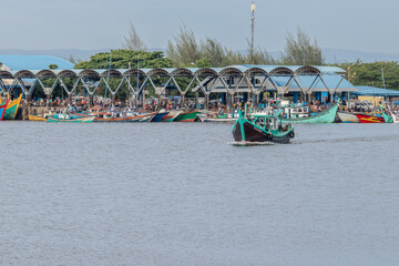 Colorful Fishing Boats at Harbor with Curved Roofs in a Coastal Town