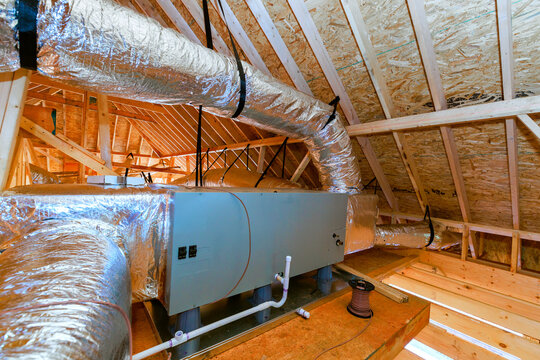 Installation of HVAC system in attic space during home construction process at residential building