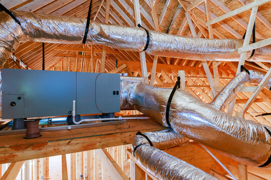 Workers install ventilation system in new building construction stage at residential area