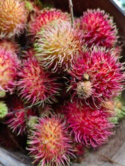 Close-up view of a pile of fresh red rambutan fruit.