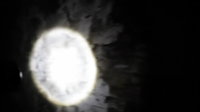 Dark Cave Exploration With Bright Flashlight Illuminating Damp Stone Walls And Water Droplets