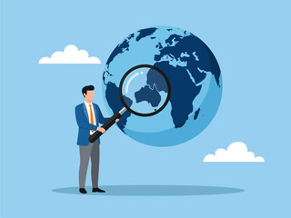 A businessman in a blue suit holds a giant magnifying glass over a floating globe, closely inspecting the continents to symbolize a strategic search for global opportunities under a clear cloudy sky