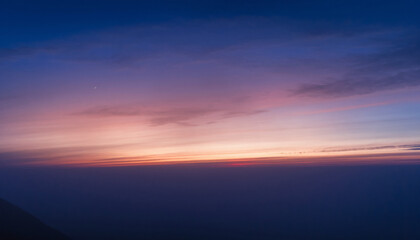 Fototapeta premium An abstract skyscape where soft gradients of blue, purple, and orange meet the horizon in a calm, cinematic moment of twilight