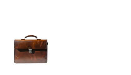 A brown leather briefcase sits against a black background. Bright light casts a shadow