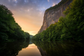 Serene river landscape with towering cliffs at sunset