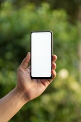 Hand holding smartphone with blank white screen outdoors
