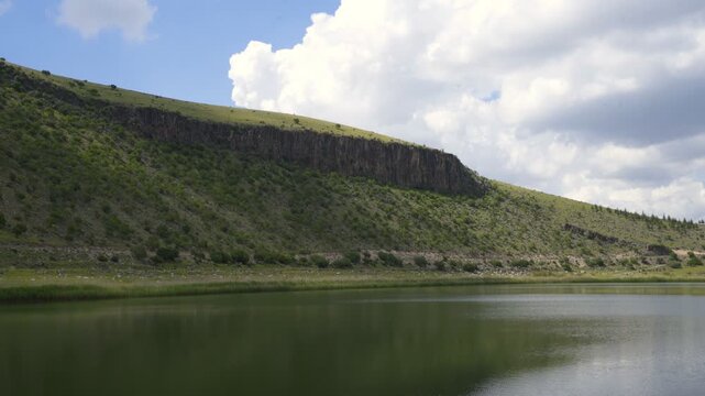 Volcanic crater lake Nar in Turkey with surrounding hills under a cloudy sky