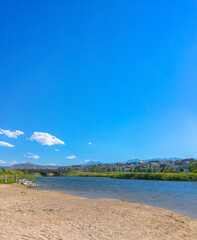Sandy shore of lake with bridge views