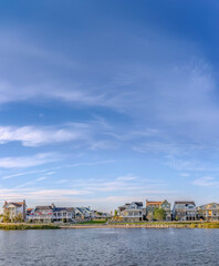 Scenic landscape with lakefront homes against sky