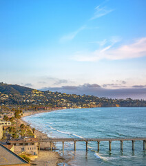 Palm trees and Pier on Manhattan Beach at sunset in California, Los Angeles, USA.