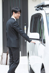 自動車のドアを開けるビジネスマン