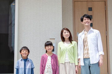 自宅の玄関先に立つ家族 © UTS