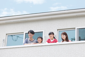 ベランダから外を見る家族