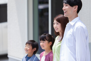 自宅の玄関先に立つ家族 © UTS