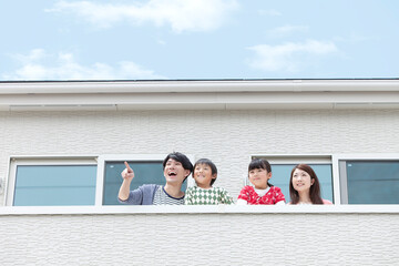 ベランダから外を見る家族