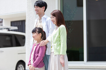 自宅の玄関先に立つ家族 © UTS