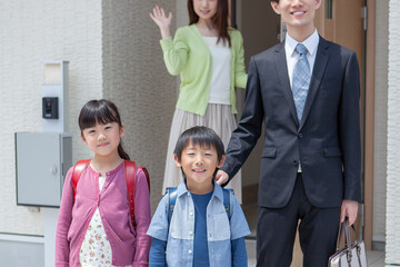 玄関先で見送る母親と家族 © UTS