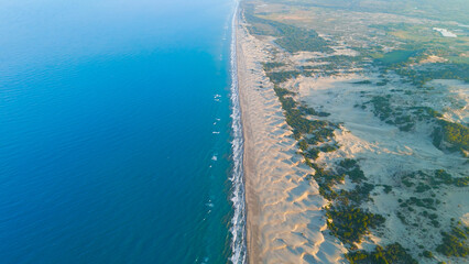 Gelemis, Turkey. Aerial view of waves on shoreline at long Patara Beach, foam and surf on sandy coast, morning light. Aerial View