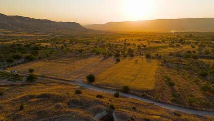 Goreme, Nevsehir, Turkey. Sun-drenched eroded plateau with intricate valley network and fairy chimneys in warm morning light over Cappadocia. Aerial View