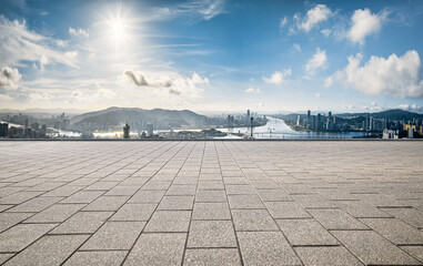 Obraz premium Empty square floor with a panoramic city skyline and river under a bright sunny sky in Macau.