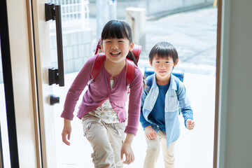 帰宅したランドセルを背負った姉弟