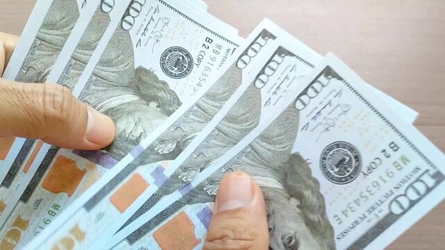 Closeup of human hands counting dollar banknotes. Caucasian man calculating income, salary, profit. Making money, success, wealth concept. Wealth. Family expenses.