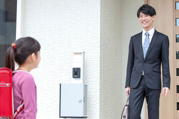 自宅を出る父親と娘
