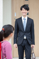 自宅を出る父親と娘