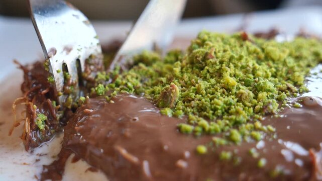 Enjoying Kunefe with chocolate and pistachio topping at a cafe