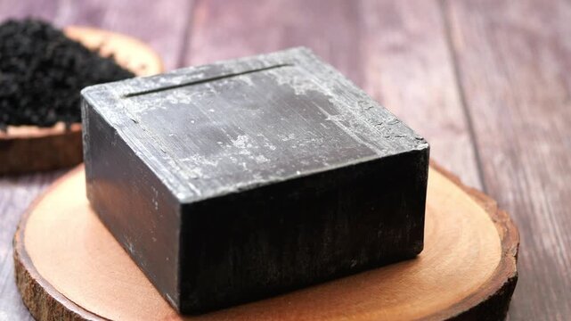 Black soap and cumin seeds on a wooden surface 