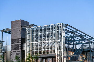 A commercial building under construction with steel framing and a masonry core, illustrating structural assembly, mixed material construction methods, and large scale commercial development.