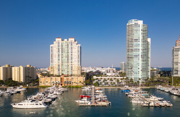 Obraz premium Miami marina with yachts and sailboats. Miami marina and turquoise ocean. Miami seascape aerial view on south beach shore. Luxury cruise ship in Miami harbor. Skyline view of Miamis cityscapes.