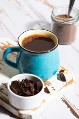 blue mug with hot chocolate on white table, vertical top view