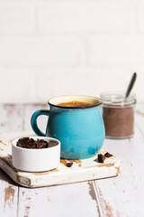 blue mug with hot chocolate on white table, vertical