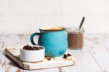 blue mug with hot chocolate on white table