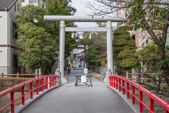 torii gate and stone bridge with red handrail in shinto shrine