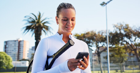 Smile, woman and reading with phone on tennis court for fitness, training app and match progress. Happy, female person and mobile with racket for sports, video demonstration and online tips for game