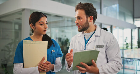 Fototapeta premium Tablet, paperwork and doctor with nurse in hospital for medical report, research or feedback. Digital technology, collaboration and team of healthcare employees in discussion for advice in clinic.