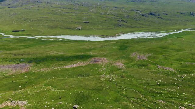 Mountain Glacial River Flowing Through A Green Valley In Kyrgyzstan. Aerial Tilt-up Shot