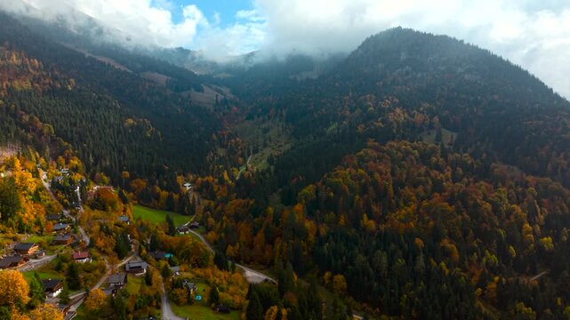 Scenic aerial of Unken village with mountains, conifer forests and rich autumn colors. Heutal, Austria