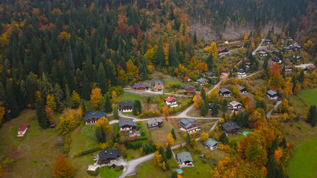 Aerial view of Unken village, Heutal, Austria. Traditional alpine houses set among bright autumn trees.