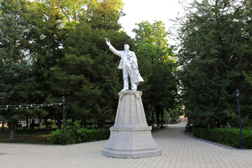 Vladimir Lenin statue on pedestal in park avenue with trees