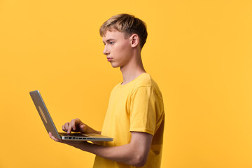 Laptop hands, yellow shirt wearer, engage with a technology device, showcasing education and...