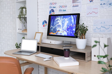 Fototapeta premium Data scientist's workplace with computer and diagrams in office